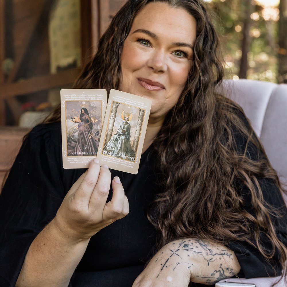 Kelly holding two tarot cards